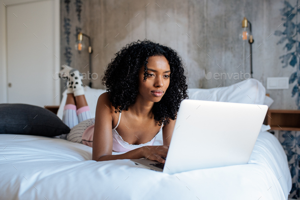 Woman sitting on bed on the computer