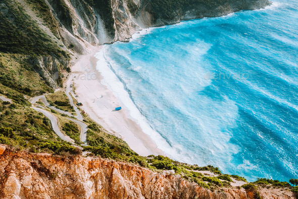 Amazing Myrtos beach with rolling waves. Beautiful coastline, cliffs surrounded the sea bay of blue - Stock Photo - Images