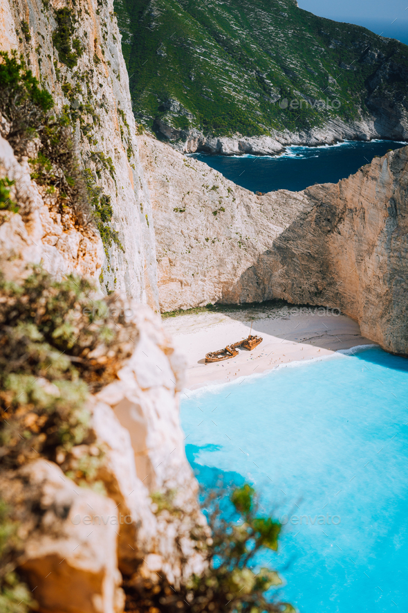 Navagio beach. Pure turquoise azure cyan teal blue sea water surrounded by huge white limestone - Stock Photo - Images