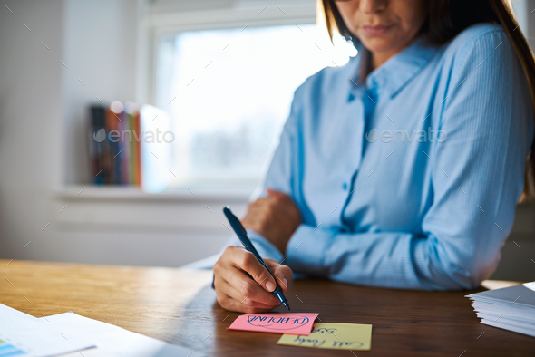 Close up of person writing on sticky notes - Stock Photo - Images