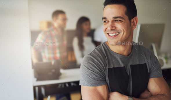 Smiling athletic man in office with co-workers - Stock Photo - Images