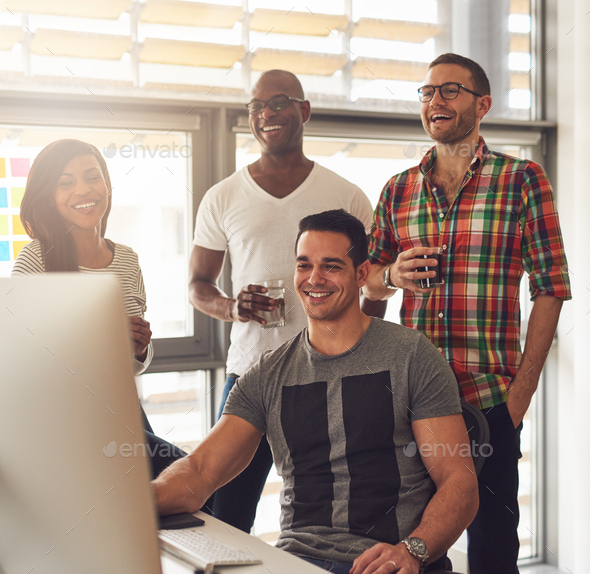 Happy quartet of young adults at desk - Stock Photo - Images