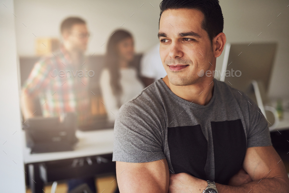 Calm muscular man in office with co-workers - Stock Photo - Images