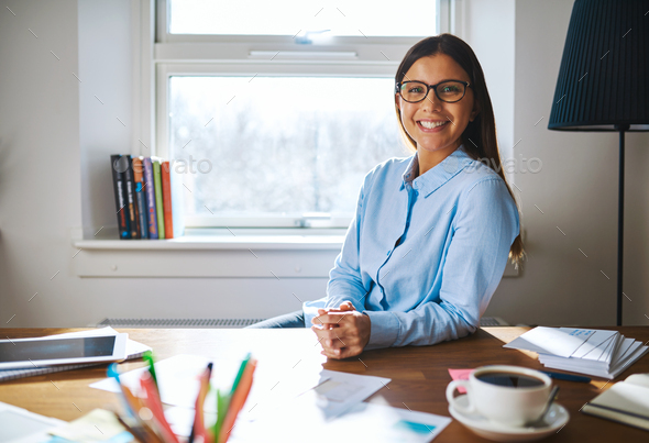 Self employed woman wearing glasses at desk - Stock Photo - Images
