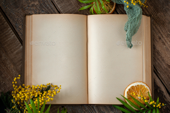 An open old book with blank pages and floral decor on an old woo - Stock Photo - Images