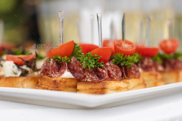 Close-up big plate with serving snack canapes fried bread tomato parsley and salami - Stock Photo - Images