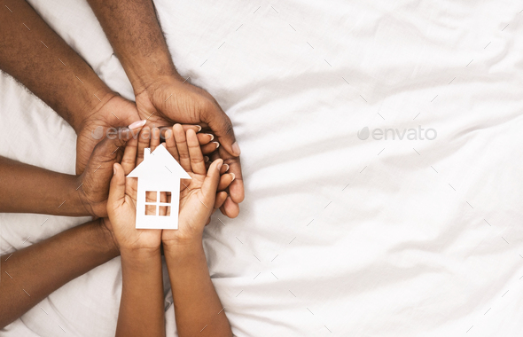Closeup of paper house in hands of african american family - Stock Photo - Images