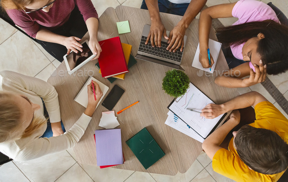 Group of international students sitting at table, top view - Stock Photo - Images