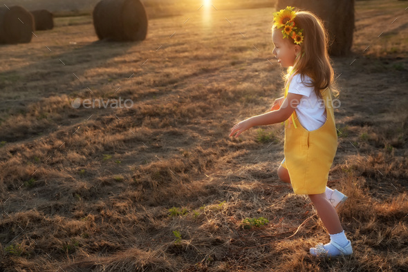 Happy girl child in yellow dress runs in autumn field - Stock Photo - Images