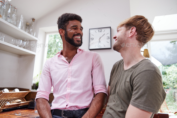 Loving Male Gay Couple Talking At Home In Kitchen Together