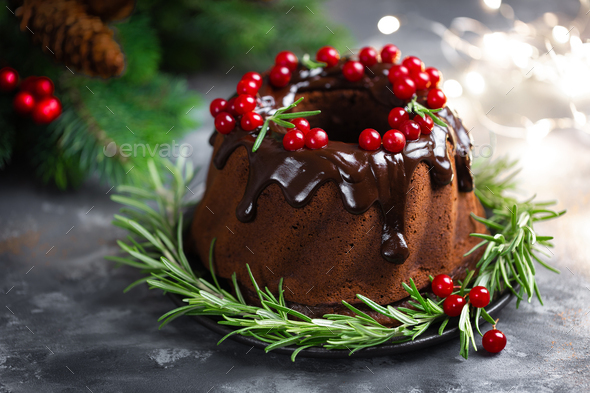 Christmas chocolate bundt cake with glaze decorated with fresh berries and rosemary - Stock Photo - Images