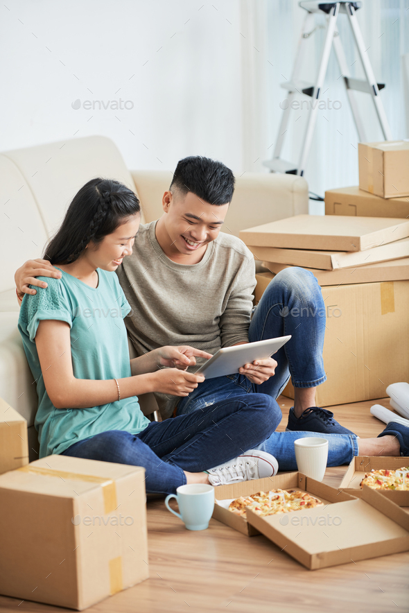 Asian couple using tablet in new flat - Stock Photo - Images