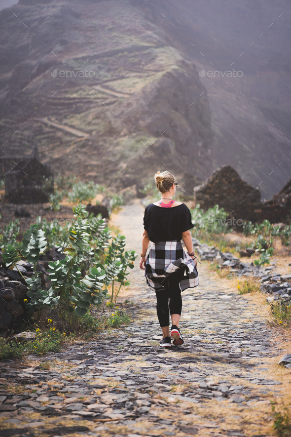 Woman hiker on the picturesque coastal cobbled route. The road joins the towns of Cruzinha - Stock Photo - Images