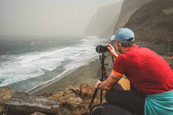 Tourist making photograph of cliff coastline with ocean waves from Cruzinha to Ponta do Sol. Huge - Stock Photo - Images