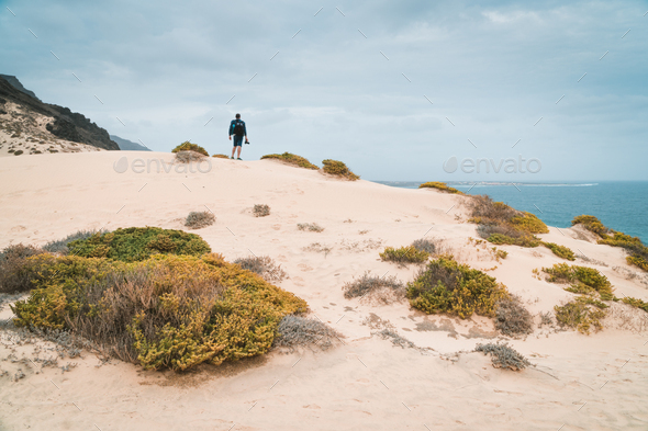Ttraveler and photographer on the top of snow-white dune landscape on the Atlantic coastline. Sao - Stock Photo - Images