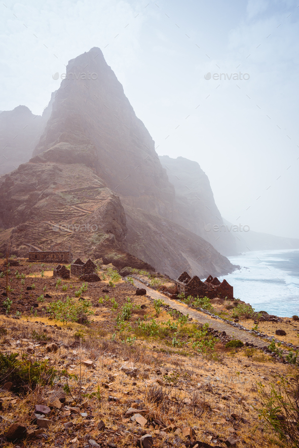 Aranhas mountain peak in the valley with house ruins and stony hiking path going up the mountain - Stock Photo - Images