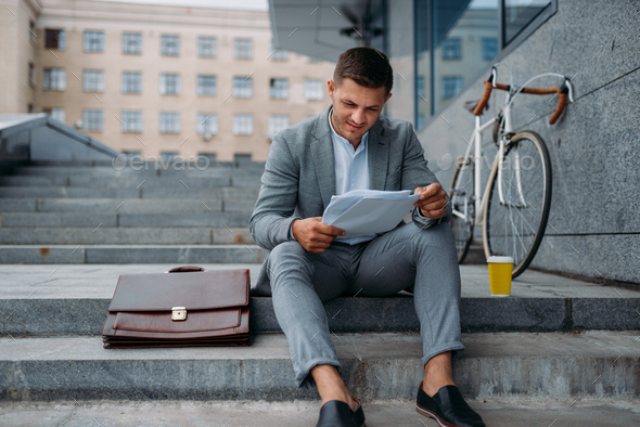 Businessman with bike having lunch at the office - Stock Photo - Images