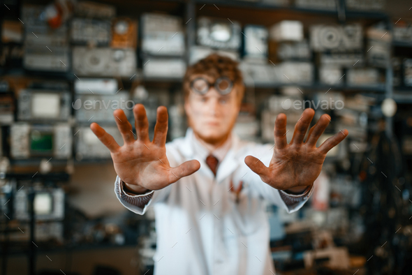 Strange scientist showing scorched hands in lab - Stock Photo - Images