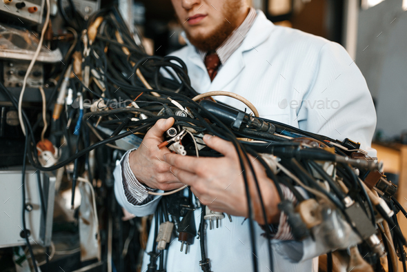 Engineer holds bunch of wires in laboratory