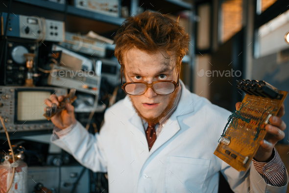 Strange engineer holds electric tube in laboratory - Stock Photo - Images