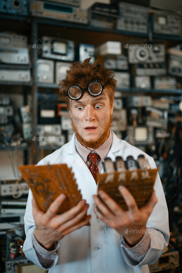 Strange engineer looks on electronic chips in lab - Stock Photo - Images
