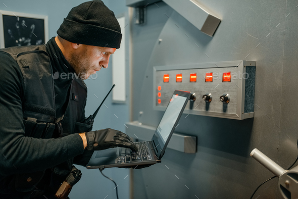 Robber with laptop trying to open the vault door