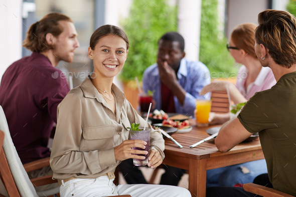 Smiling Woman Enjoying Lunch with Friends in Cafe - Stock Photo - Images