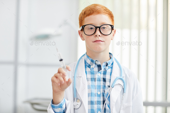 Little Boy laying Doctor and Holding Syringe