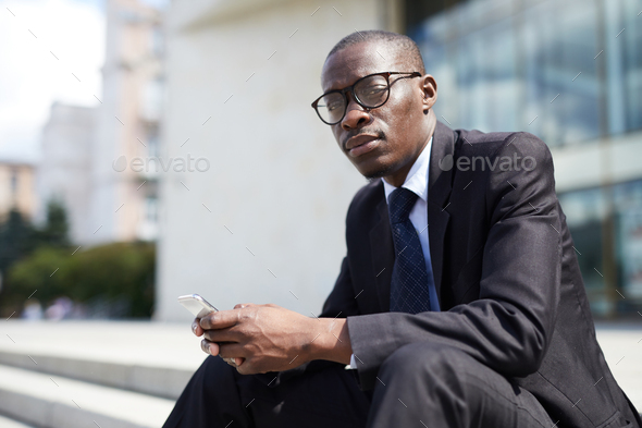 African-American Businessman Sitting on Steps - Stock Photo - Images