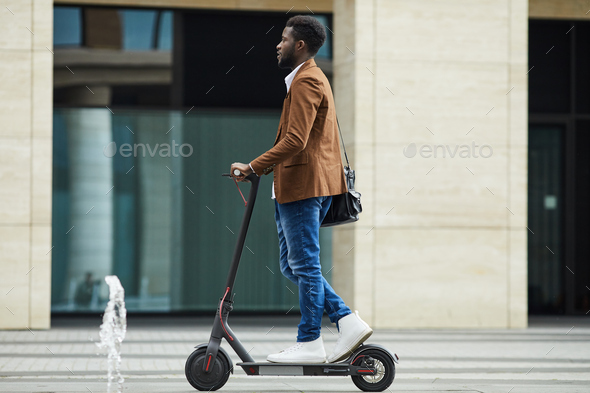 African Man Riding Electric Scooter Background - Stock Photo - Images