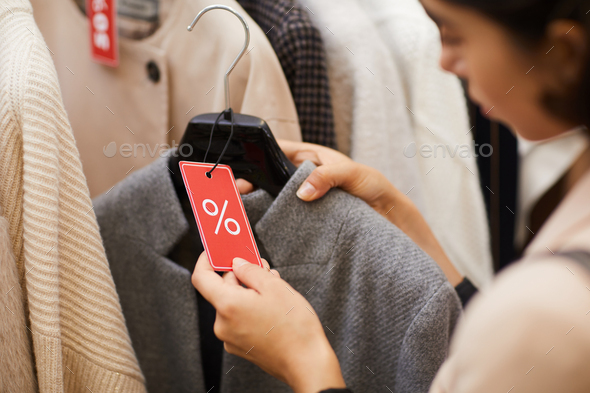 Young Woman Choosing Clothes on Sale - Stock Photo - Images