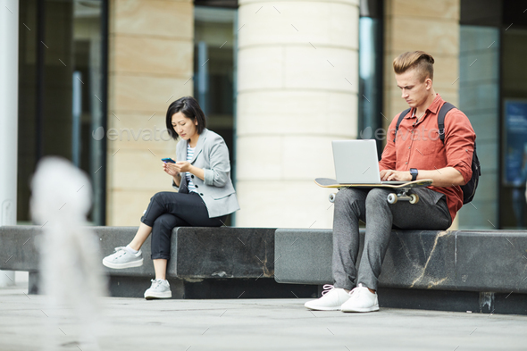 Young People Using Electronic Devices in City - Stock Photo - Images