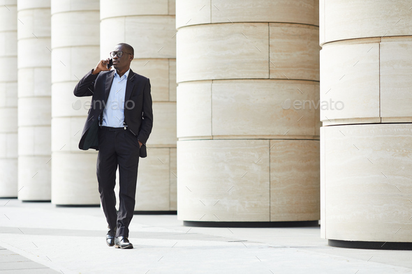 African-American Businessman walking in City - Stock Photo - Images