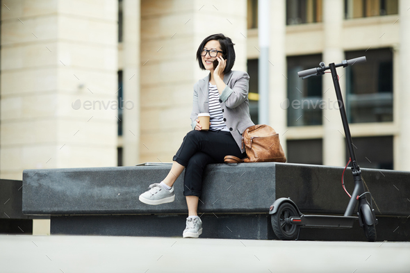 Modern Asian Woman Speaking by Smartphone Outdoors - Stock Photo - Images