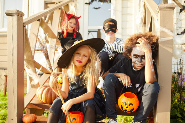 Kids Sitting on Porch on Halloween - Stock Photo - Images