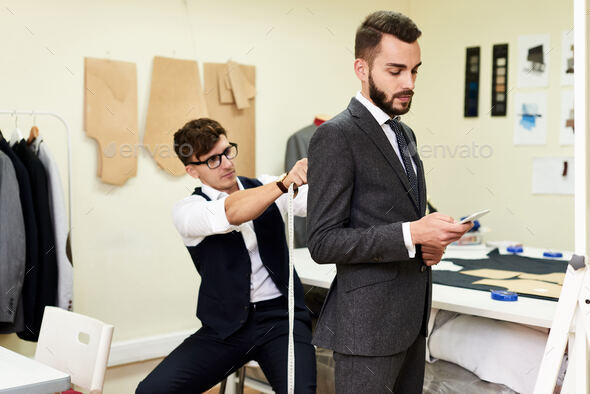 Tailor Fitting Handsome Businessman for Bespoke Suit