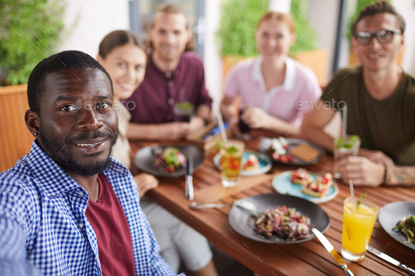 African Man Taking Selfie Photo with Friends in Cafe - Stock Photo - Images