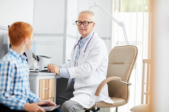 Senior Doctor Talking to Teenage Boy - Stock Photo - Images