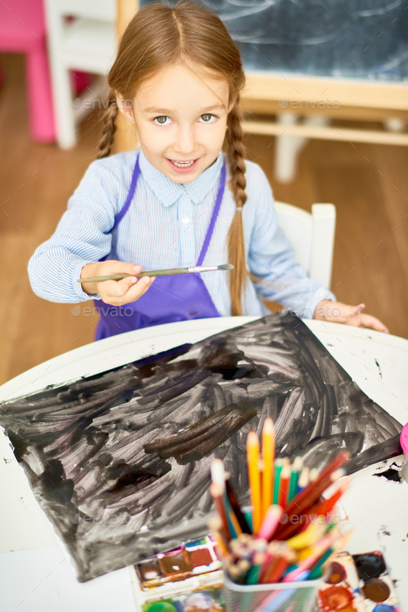 Cute Girl Painting Halloween Pictures in Art Class