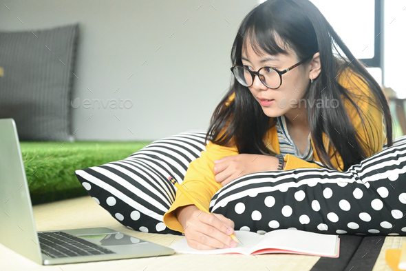 Teenage female student sleep on pillows read book and use laptop.