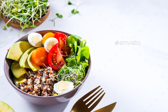Fresh healthy salad with quinoa, cherry tomatoes and mixed greens, avocado, egg and micro greens on - Stock Photo - Images