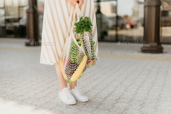 Zero waste concept with copy space. Woman holding cotton shopper and reusable mesh shopping bags - Stock Photo - Images