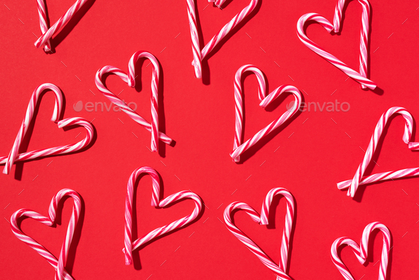 Pattern with hearts made of Christmas candy canes on red background. Top view. Flat lay. Love - Stock Photo - Images