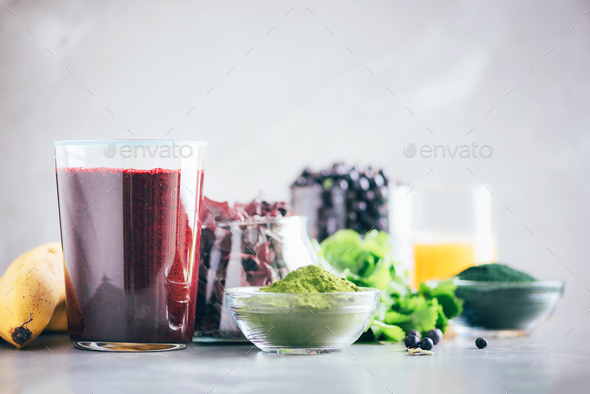 Healthy eating, alkaline diet, vegan concept. Blueberries, bilberry, barley grass juice, spirulina - Stock Photo - Images