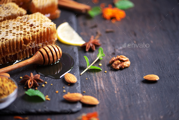 Autumn picnic. Herbal tea, honey and bee products, apple, lemon, calendula,  spices on dark Stock Photo by jchizhe