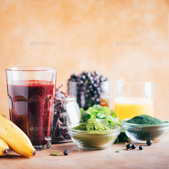 Fresh blueberries, bilberry, barley grass, spirulina powder, orange juice, dulse, cilantro on marble - Stock Photo - Images
