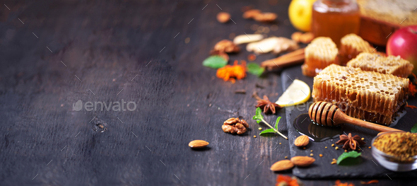 Autumn harvest concept. Set of honey and bee products, apple, lemon, spices on dark background
