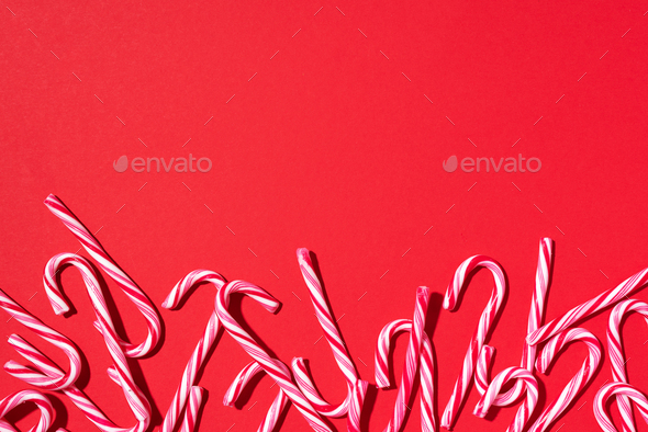Christmas candy canes on red background. Top view. Flat lay. Creative minimal concept. Greeting card - Stock Photo - Images