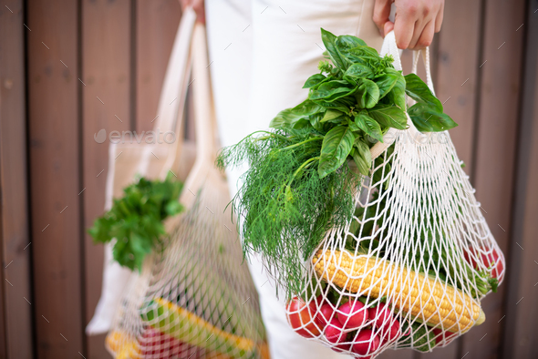 Zero waste concept with copy space. Woman holding cotton shopper and reusable mesh shopping bags - Stock Photo - Images
