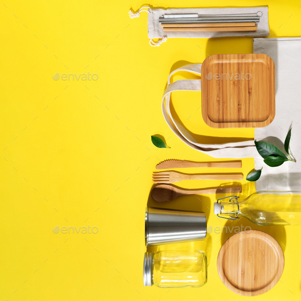 Cotton bags, glass jar, bottle, metal cup, straws for drinking, bamboo cutlery and boxes on yellow - Stock Photo - Images